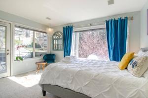 a bedroom with a bed and a large window at Gorgeous Queen Anne Townhouse - Rooftop Deck! in Seattle