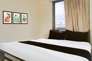 a bedroom with a white bed with a window at Hotel O Destination 41 in Pune