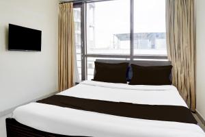 a bedroom with a large bed and a window at Hotel O Destination 41 in Pune