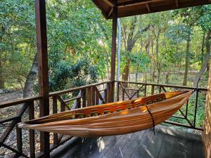 a hammock sitting on a porch of a house at Real Jamaica - 5 Cabins right beside the sea in Oracabessa +42 photos