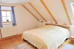 a bedroom with a white bed and a window at Retreat in the Bohemian Forest in Schöneben