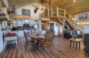 a kitchen and living room with a table and a staircase at Homestake Cabin in Creede