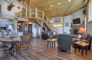 a living room with wooden floors and a wooden staircase at Homestake Cabin in Creede