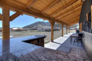 an outdoor kitchen with a wooden pergola at Homestake Cabin in Creede