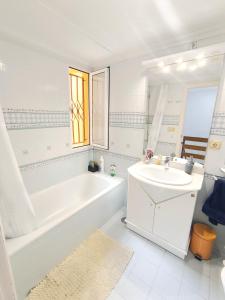 Un baño blanco con bañera y lavabo. en Habitación Cabo Huertas, en Alicante 26 fotos más