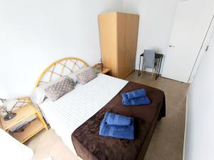Un dormitorio con una cama con dos toallas azules encima. en Habitación Cabo Huertas, en Alicante