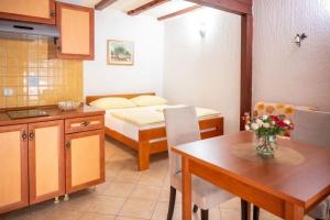 kuchnia i jadalnia ze stołem i łóżkiem w obiekcie Apartments with parking spaces Povljana, Pag - 233 w mieście Povljana