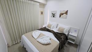 a bedroom with a bed with towels on it at Flat Lindíssimo de 2qts uma esquina do Flamboyant Shopping 206 in Goiânia