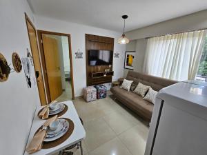 a living room with a couch and a tv at Flat Lindíssimo de 2qts uma esquina do Flamboyant Shopping 206 in Goiânia