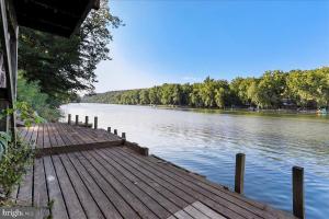a wooden dock on a lake with trees in the background at Rivers Edge - On the River, Breathtaking views! in Front Royal