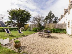 a patio with chairs and a table in a yard at Charmante maison de paludier à Guérande, proche mer, jardin, tyrolienne, WIFI, Canal+, équipements bébé - FR-1-306-1102 in Guérande