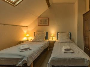 two beds in a small room with two lamps at Charmante maison de paludier à Guérande, proche mer, jardin, tyrolienne, WIFI, Canal+, équipements bébé - FR-1-306-1102 in Guérande