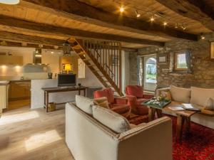 a living room with a couch and chairs and a kitchen at Charmante maison de paludier à Guérande, proche mer, jardin, tyrolienne, WIFI, Canal+, équipements bébé - FR-1-306-1102 in Guérande