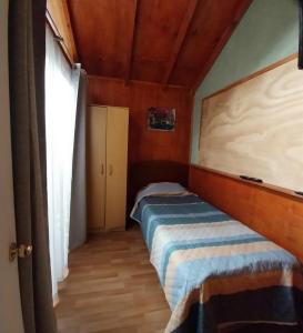 een kleine slaapkamer met een bed in een kamer bij Alquiler House in Puerto Montt