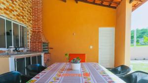 a table and chairs in a kitchen with an orange wall at Casa em Alambari com Area Gourmet e Piscina in Alambari