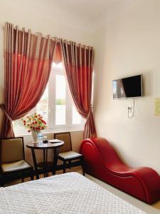 Un dormitorio con una cama y una mesa y una ventana. en Khách Sạn Sơn Hạ, en Kon Tum