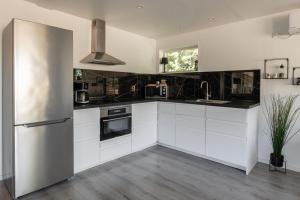 a kitchen with white cabinets and a stainless steel refrigerator at Landvetter Apartment in Landvetter