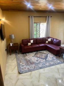 a living room with a brown leather couch and a rug at Whitehall Villa in Negril in Negril +69 photos