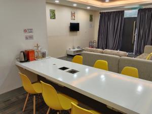 a waiting room with a table and chairs and a couch at Muallim Home in Mersing