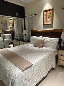 a bedroom with a large white bed and a mirror at Villa Christine in Ocho Rios