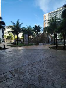 a large plaza with palm trees and a building at Swiss Garden resort residence by Moonlight in Kuantan