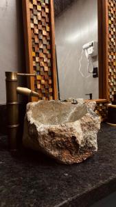 a stone sink sitting on a counter in a room at Chalés Piribless-Oásis in Pirenópolis +8 photos