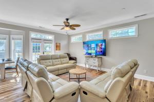 Una sala de estar con sofás y un televisor de pantalla plana. en Heated Pool l Indoor Jacuzzi Tubs I Arcade l Outdoor Hot Tub, en Winston-Salem