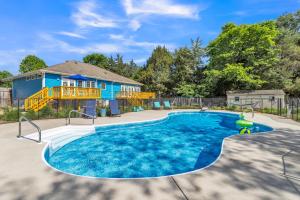 una piscina frente a una casa azul en Heated Pool l Indoor Jacuzzi Tubs I Arcade l Outdoor Hot Tub, en Winston-Salem