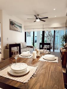 a dining room table with plates and wine glasses on it at Ipana Luxury by Felix in Playa del Carmen