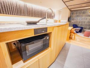 a kitchen with a sink and a microwave at The GALA Hotel Umeda in Osaka +111 photos