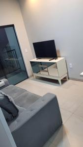 a living room with a tv and a couch at Apartamento 3 completo centro in Sorriso