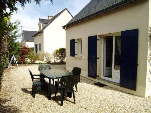 een patio met een tafel en stoelen naast een huis bij Maisonnette Maria in Saint-Gildas-de-Rhuys