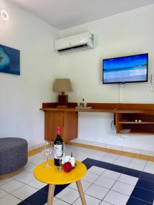 Una sala de estar con una botella de vino y una mesa. en Le Cocon Miel - Plage, Jardin, Adapté aux Groupes, en Folle Anse 12 fotos más