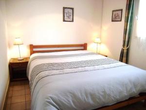 サルゾーにあるMaisonnette Elenのベッドルーム(白い大型ベッド、ランプ2つ付)