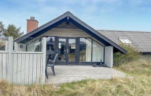 una casa con una terrazza con una sedia sopra di 3 Bedroom Amazing Home In Ringkøbing a Ringkøbing Altre 4 foto
