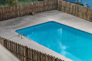 an empty swimming pool next to a wooden fence at Garden Level 1BR condo, Central Luxury Suite in Wilmington