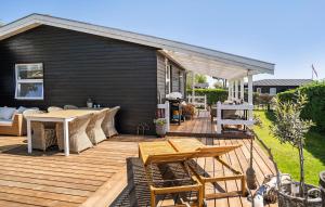 a wooden deck with a table and chairs on it at 2 Bedroom Cozy Home In Juelsminde in Sønderby +9 photos