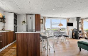 a kitchen and living room with a table and chairs at 2 Bedroom Cozy Home In Juelsminde in Sønderby