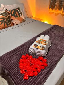 a bed with towels and red roses on it at Casa Mundo Buzios in Buzios