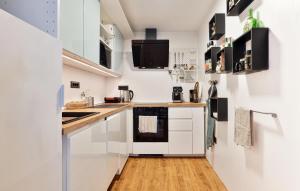 ロヴランにある2 Bedroom Stunning Apartment In Lovranの白いキャビネットと木製の床を備えたキッチン