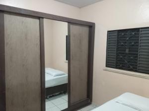 a mirror in a room with a bed and a window at Casa in Fortaleza