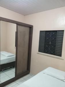 a mirror in a room with a bed and a window at Casa in Fortaleza +3 photos