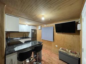 a kitchen with a counter and a tv on the wall at Cabaña Esperanza in Ancud