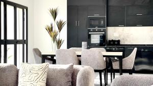 a dining room with a table and chairs and a kitchen at Villa de Naël in Bin Rhilouf