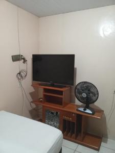 a living room with a television and a fan at Casa in Fortaleza