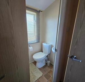 フランボローにあるZapata Springs 34のトイレと窓のある小さなバスルーム +2枚の写真