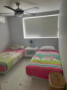 ein Schlafzimmer mit zwei Betten und einem Deckenventilator in der Unterkunft Exclusivo Alojamiento en Real diamante in Acapulco