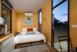a small bedroom with a bed and a sliding glass door at Pyrenees Views by Tiny Away in Avoca