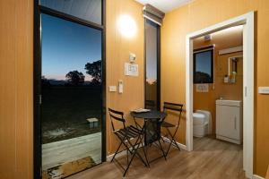 a room with a table and chairs and a bathroom at Pyrenees Views by Tiny Away in Avoca