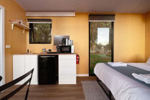 a room with a kitchen with a microwave and a bed at Pyrenees Views by Tiny Away in Avoca